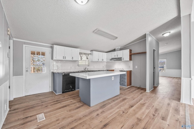 kitchen featuring white cabinets, a center island, a healthy amount of sunlight, and light hardwood / wood-style floors