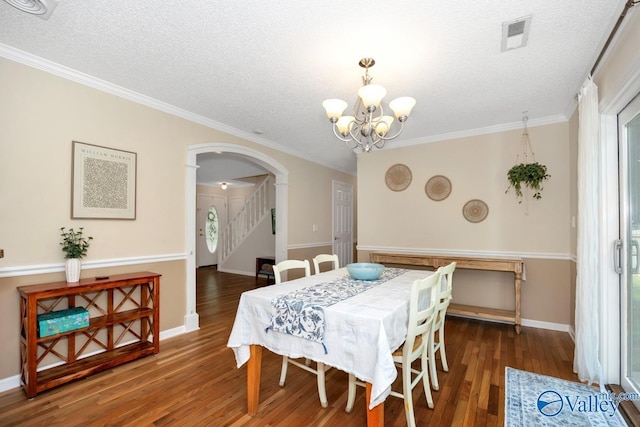 1867 Shellbrook Dr, Huntsville, AL 35806 - dining area with arched walkways, a chandelier, a textured ceiling, wood finished floors, and ornamental molding