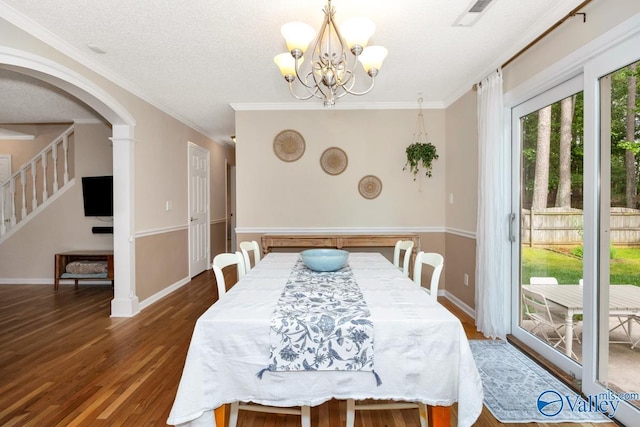 1867 Shellbrook Dr, Huntsville, AL 35806 - dining room featuring wood finished floors, a chandelier, stairway, arched walkways, and baseboards