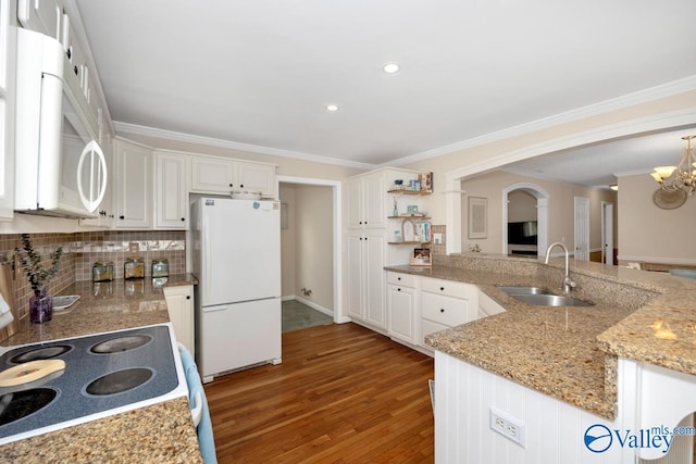 1867 Shellbrook Dr, Huntsville, AL 35806 - kitchen featuring white appliances, a sink, arched walkways, light wood-style floors, and a chandelier
