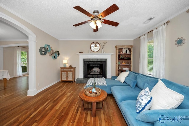 1867 Shellbrook Dr, Huntsville, AL 35806 - living area with arched walkways, a ceiling fan, wood finished floors, a tile fireplace, and a textured ceiling