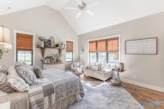 bedroom with high vaulted ceiling, multiple windows, ceiling fan, and hardwood / wood-style floors