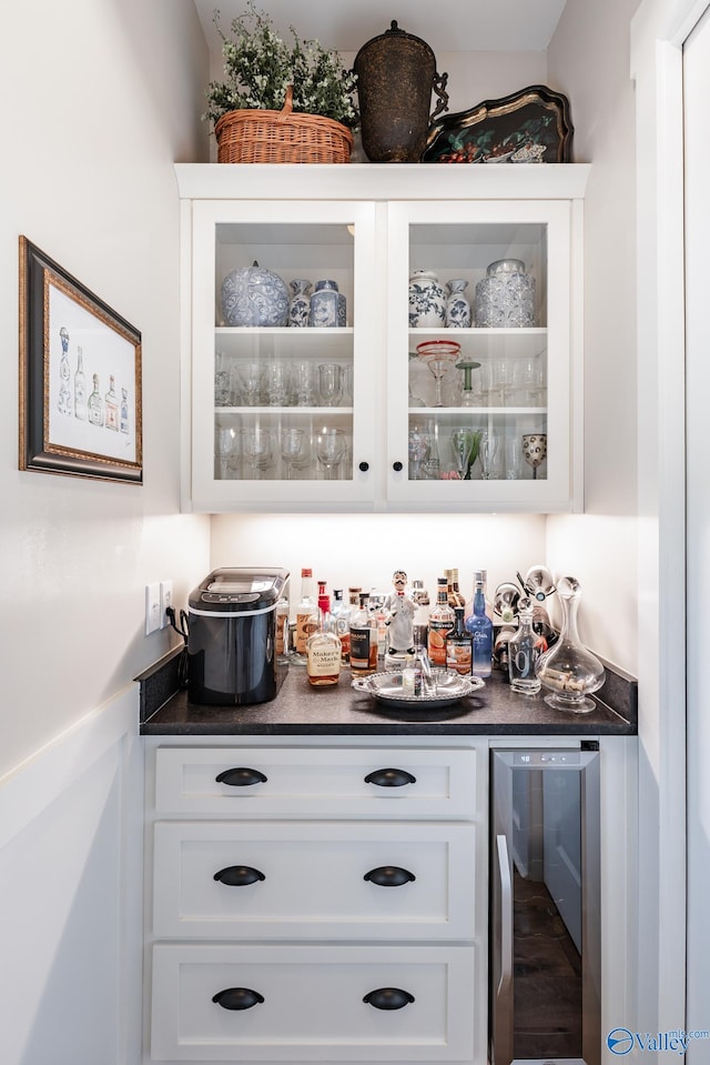 bar with white cabinetry, hardwood / wood-style flooring, and beverage cooler