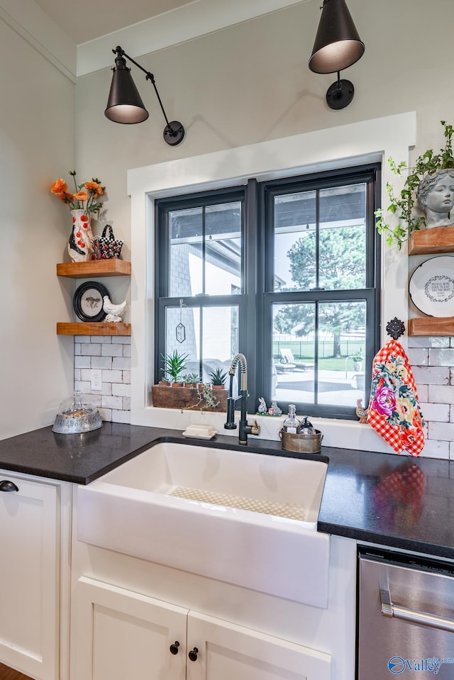 kitchen with white cabinetry, backsplash, and stainless steel dishwasher