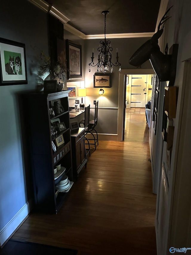 hall featuring an inviting chandelier, crown molding, and hardwood / wood-style floors