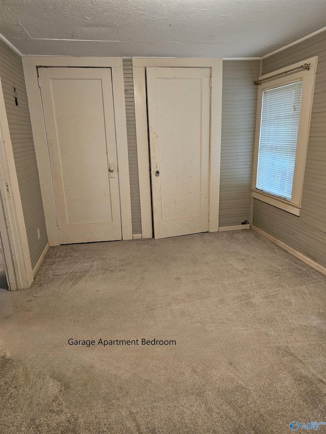 unfurnished bedroom with light carpet and a textured ceiling