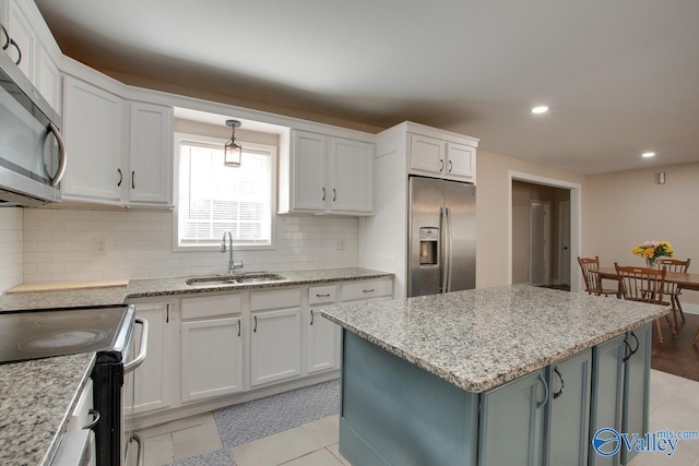 kitchen featuring stainless steel appliances, a center island, sink, and white cabinets