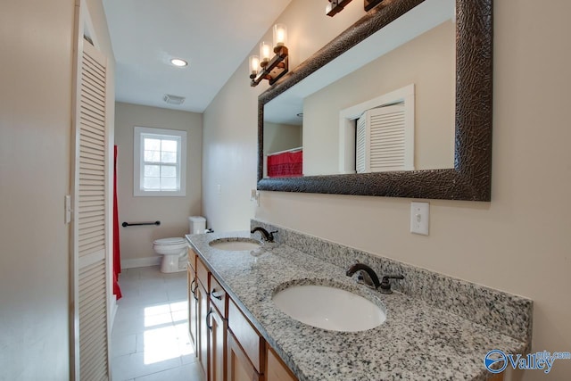 bathroom with tile patterned flooring, vanity, and toilet