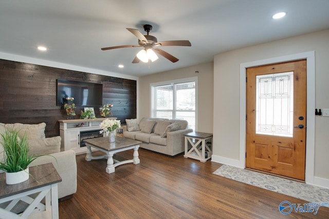 living room featuring dark wood-type flooring and ceiling fan