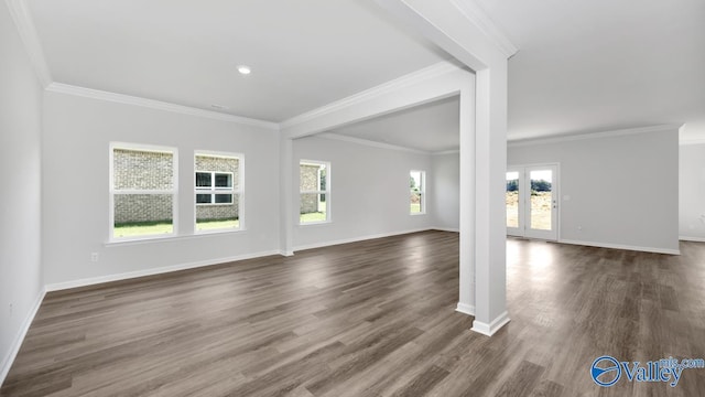 unfurnished living room with baseboards, plenty of natural light, dark wood-style floors, and ornamental molding