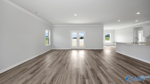 unfurnished living room featuring visible vents, a sink, recessed lighting, baseboards, and dark wood-style flooring