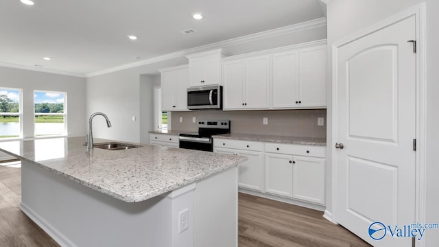 kitchen featuring crown molding, wood finished floors, appliances with stainless steel finishes, and a sink