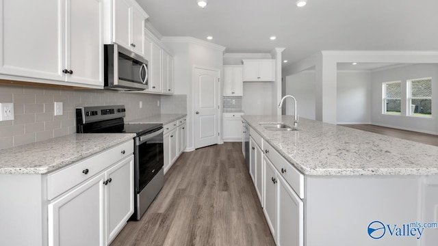 kitchen featuring a sink, light wood-style flooring, appliances with stainless steel finishes, and white cabinets