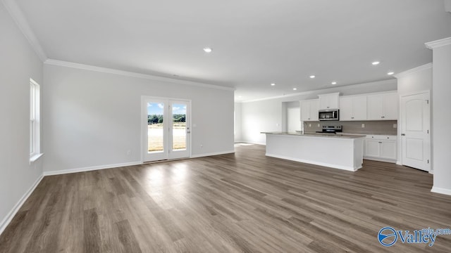 unfurnished living room featuring recessed lighting, wood finished floors, baseboards, and ornamental molding