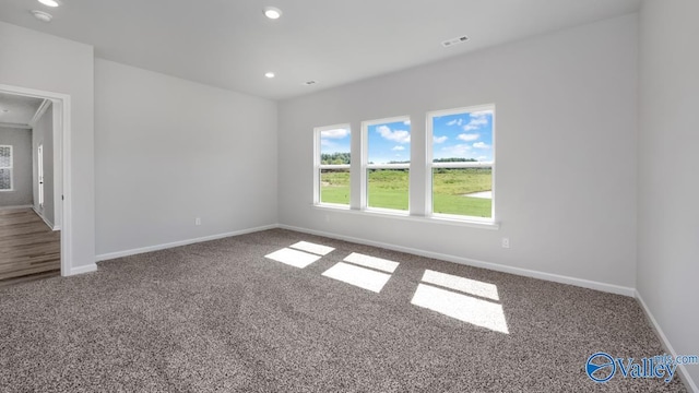 carpeted spare room featuring visible vents, recessed lighting, and baseboards