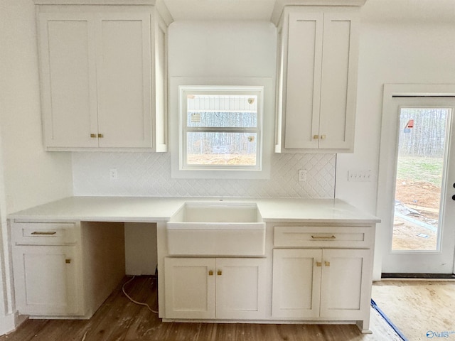 kitchen featuring tasteful backsplash, white cabinets, wood-type flooring, and a wealth of natural light