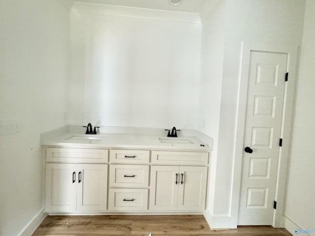 bathroom featuring hardwood / wood-style flooring, vanity, and ornamental molding