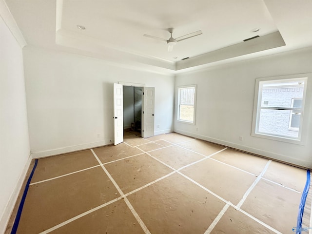 unfurnished bedroom featuring ceiling fan and a tray ceiling