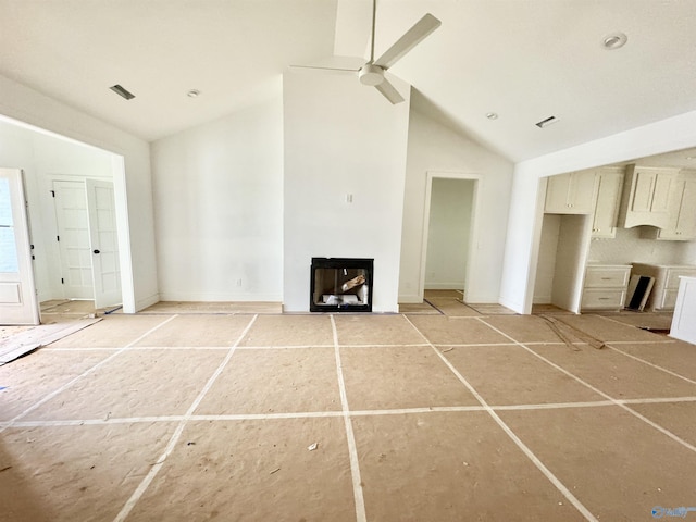 unfurnished living room with ceiling fan and high vaulted ceiling