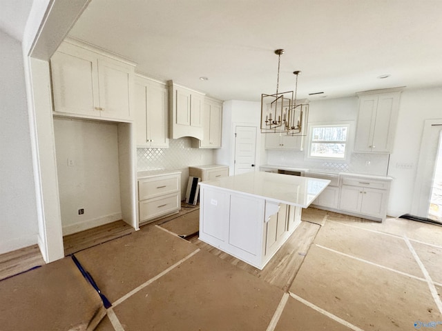 kitchen with backsplash, decorative light fixtures, a center island, and white cabinets