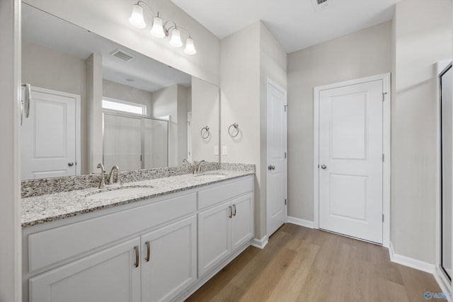 bathroom with wood-type flooring, vanity, and walk in shower