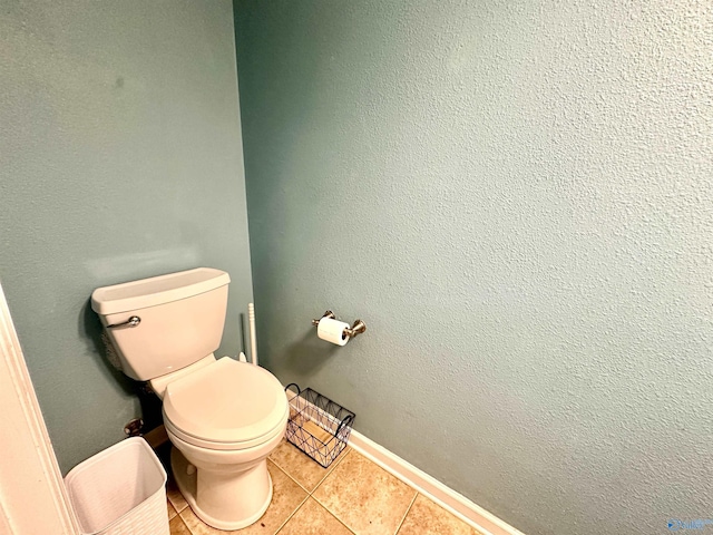 bathroom featuring tile patterned flooring, toilet, and baseboards