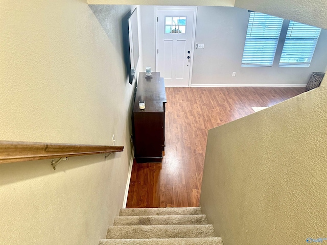 interior space featuring a healthy amount of sunlight, stairs, baseboards, and wood finished floors