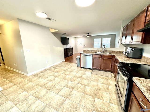 kitchen featuring a sink, visible vents, baseboards, open floor plan, and appliances with stainless steel finishes