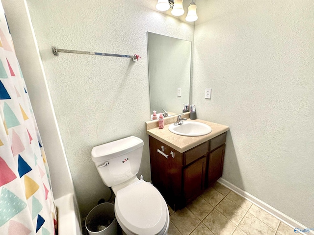 full bathroom featuring a textured wall, tile patterned flooring, toilet, vanity, and baseboards