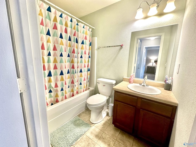 bathroom featuring a textured wall, toilet, tile patterned floors, shower / bath combo with shower curtain, and vanity