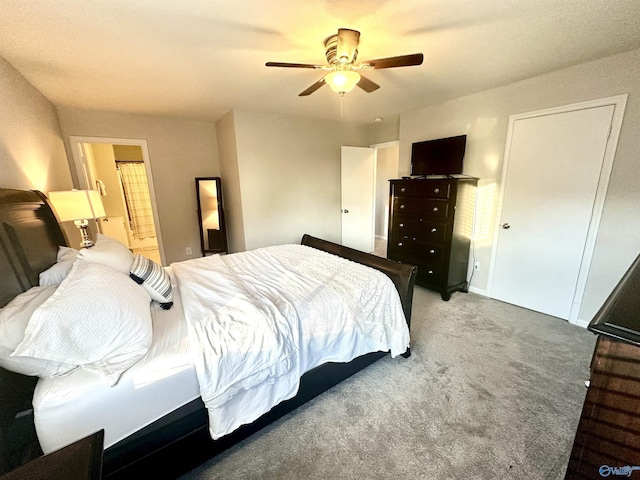 bedroom featuring ensuite bathroom, carpet floors, and a ceiling fan