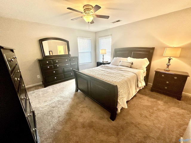 carpeted bedroom with ceiling fan, visible vents, and baseboards