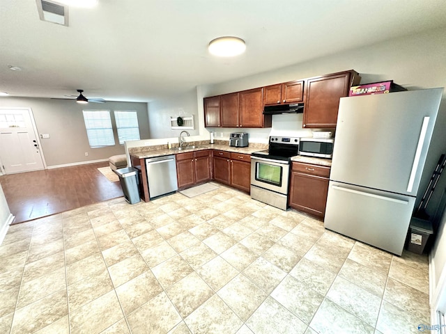 kitchen featuring stainless steel appliances, visible vents, light countertops, under cabinet range hood, and baseboards