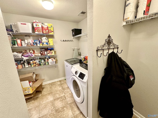 clothes washing area featuring laundry area, light tile patterned floors, baseboards, visible vents, and washer and dryer