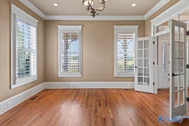 unfurnished room with crown molding, plenty of natural light, and french doors