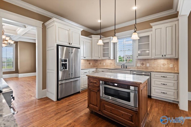 kitchen featuring white cabinetry, appliances with stainless steel finishes, a kitchen island, and light stone counters