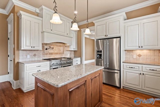 kitchen featuring white cabinetry, decorative light fixtures, light stone counters, and premium appliances