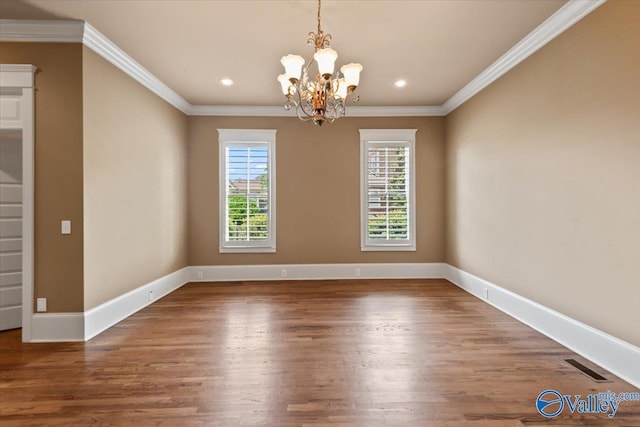 unfurnished dining area with hardwood / wood-style flooring, ornamental molding, and a notable chandelier