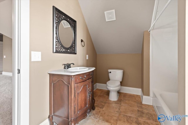 bathroom with vanity, a bathtub, vaulted ceiling, and toilet