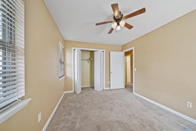 unfurnished bedroom featuring carpet, a textured ceiling, and baseboards