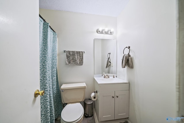 bathroom with vanity, toilet, and a textured ceiling