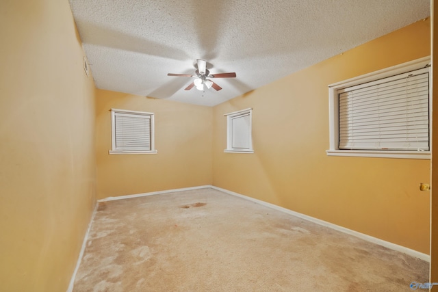 carpeted spare room with a ceiling fan, a textured ceiling, and baseboards