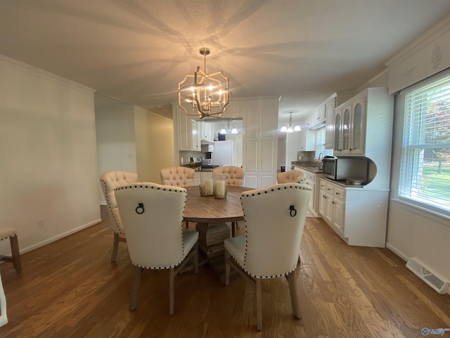 1702 Roseberry Dr, Scottsboro, AL 35769 - dining space with crown molding, visible vents, a chandelier, and baseboards