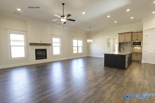 kitchen featuring ornamental molding, dark hardwood / wood-style flooring, a center island with sink, and sink