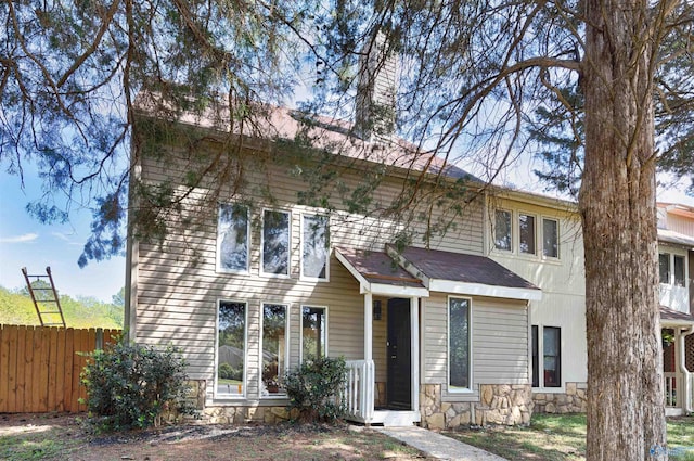 409 Hobbs Rd SE, Huntsville, AL 35803 - view of front of home featuring stone siding, a chimney, and fence