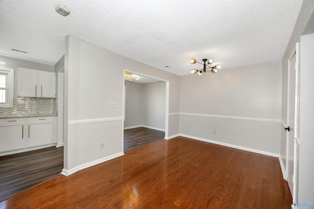 409 Hobbs Rd SE, Huntsville, AL 35803 - unfurnished dining area featuring a chandelier, dark wood-type flooring, and a textured ceiling