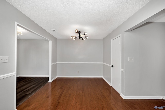 409 Hobbs Rd SE, Huntsville, AL 35803 - empty room with wood finished floors, visible vents, baseboards, a textured ceiling, and a notable chandelier