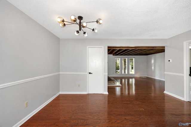 409 Hobbs Rd SE, Huntsville, AL 35803 - unfurnished room with wood finished floors, a textured ceiling, baseboards, and an inviting chandelier