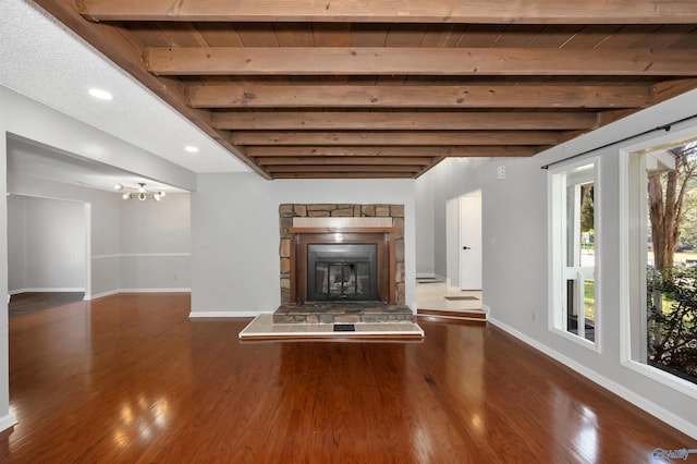 409 Hobbs Rd SE, Huntsville, AL 35803 - unfurnished living room featuring wood finished floors, beamed ceiling, baseboards, a fireplace, and a notable chandelier