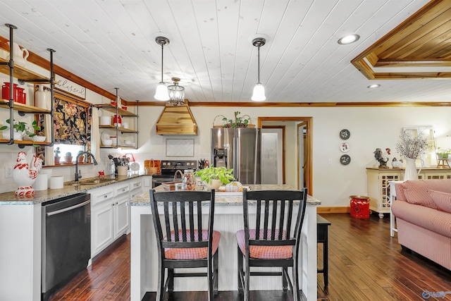 kitchen featuring appliances with stainless steel finishes, hanging light fixtures, dark hardwood / wood-style flooring, custom exhaust hood, and sink